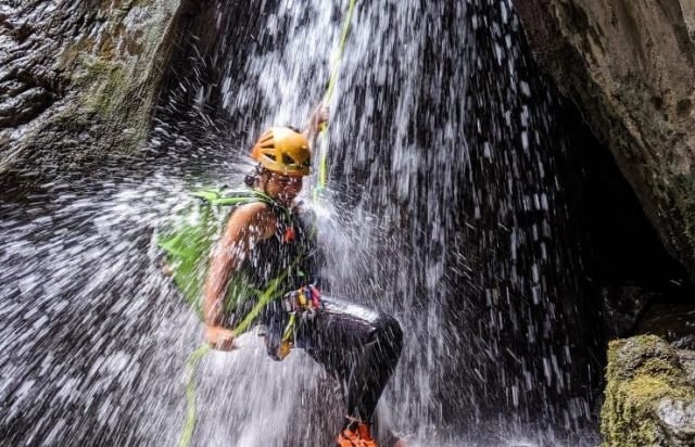 Rappelling down a waterfall while canyoning